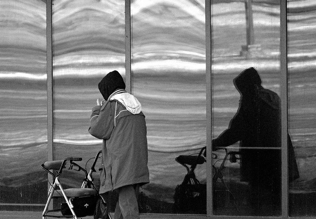 A man casts a shadow as he walks by the windows outside a supportive hosuing complex in Edmonton, Canada on January 11, 2021.