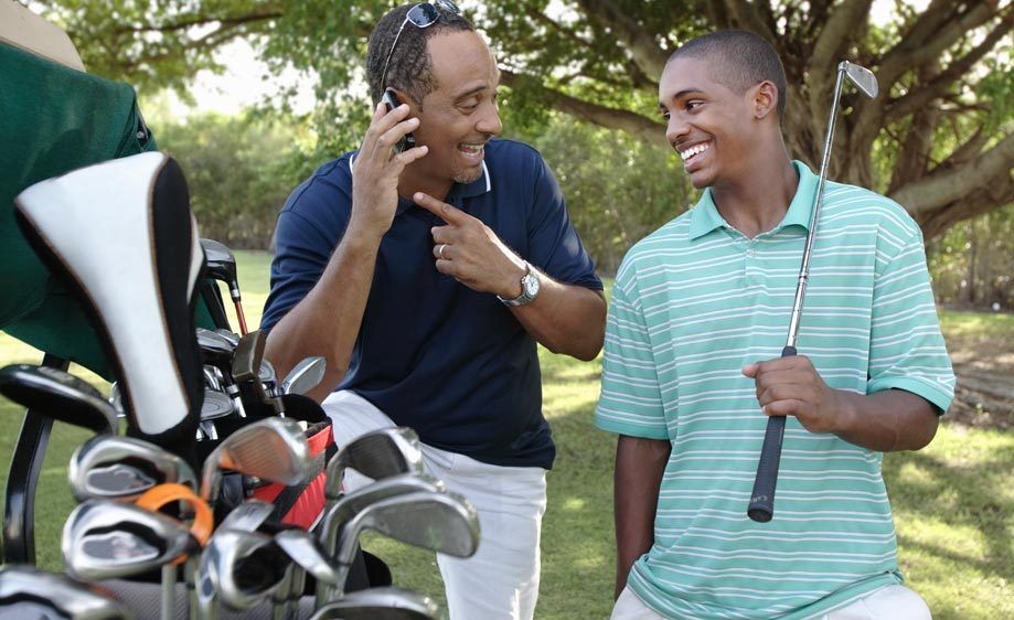 1Fater_and_son_golf_dad_on_cell_phone.jpg