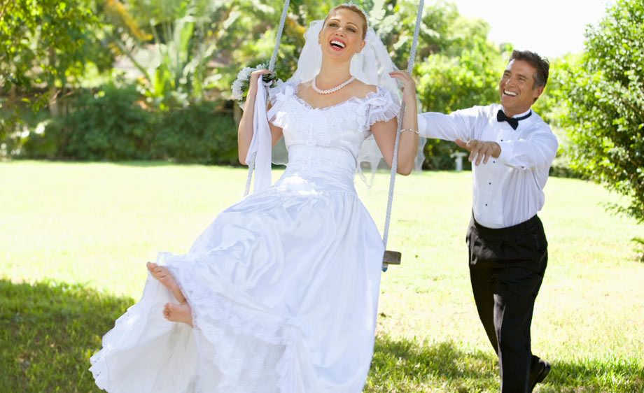 1Smiling_groom_pushes_his_bride_on_a_swing.jpg