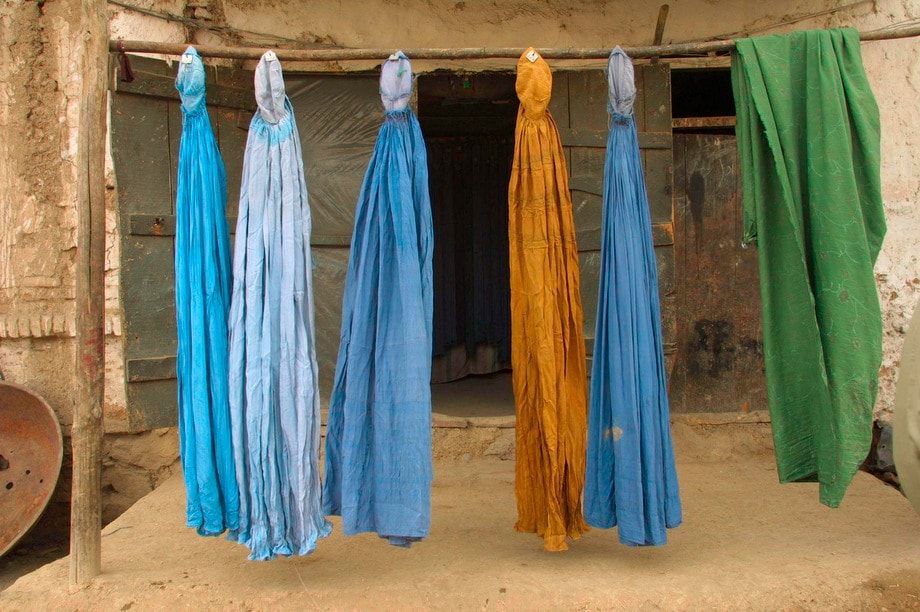 Burqas dry outside on a street in Kabul.  
