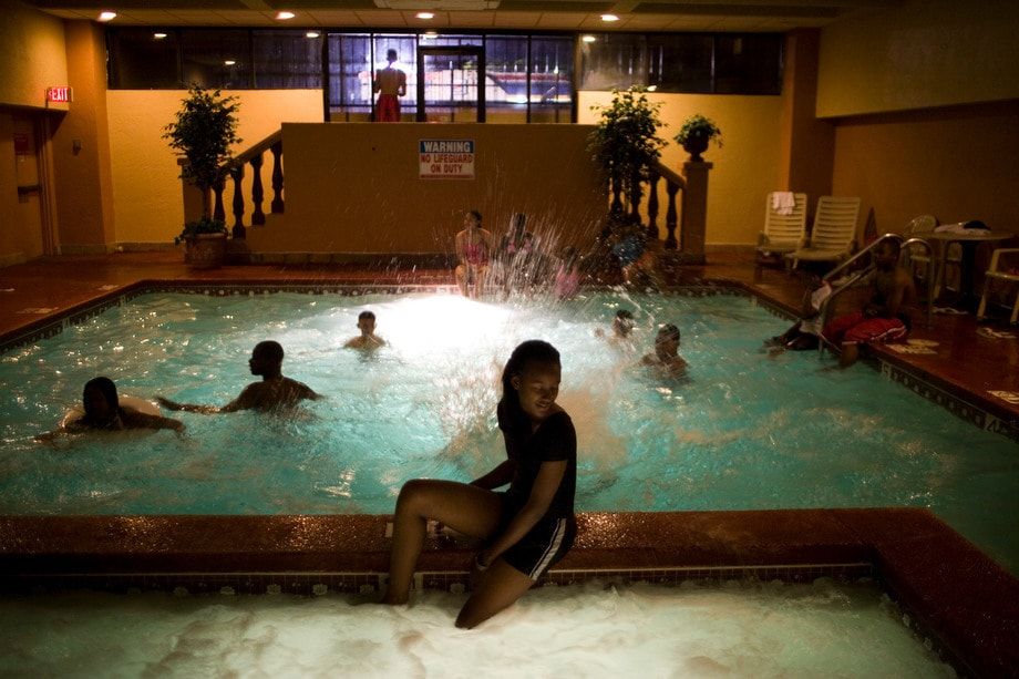 Teenagers and Mentors from the Godparents Youth Organization relax at the pool. 