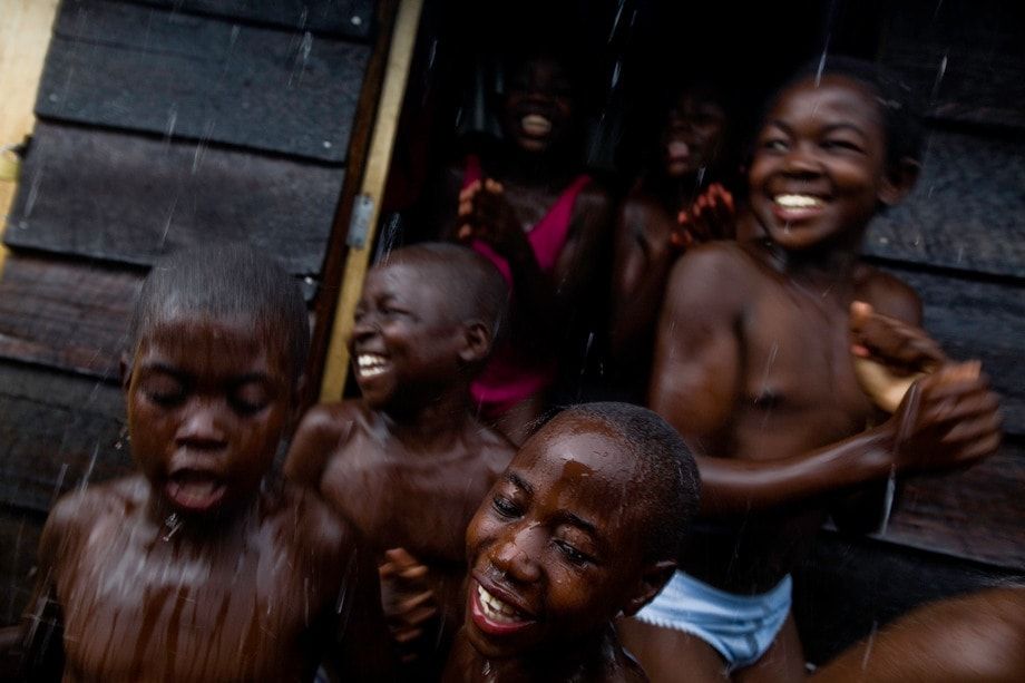 Orphaned and lost children spontaneously dance and sing in the rain at the Centre Covedec in Goma.  © Ron Haviv - VII