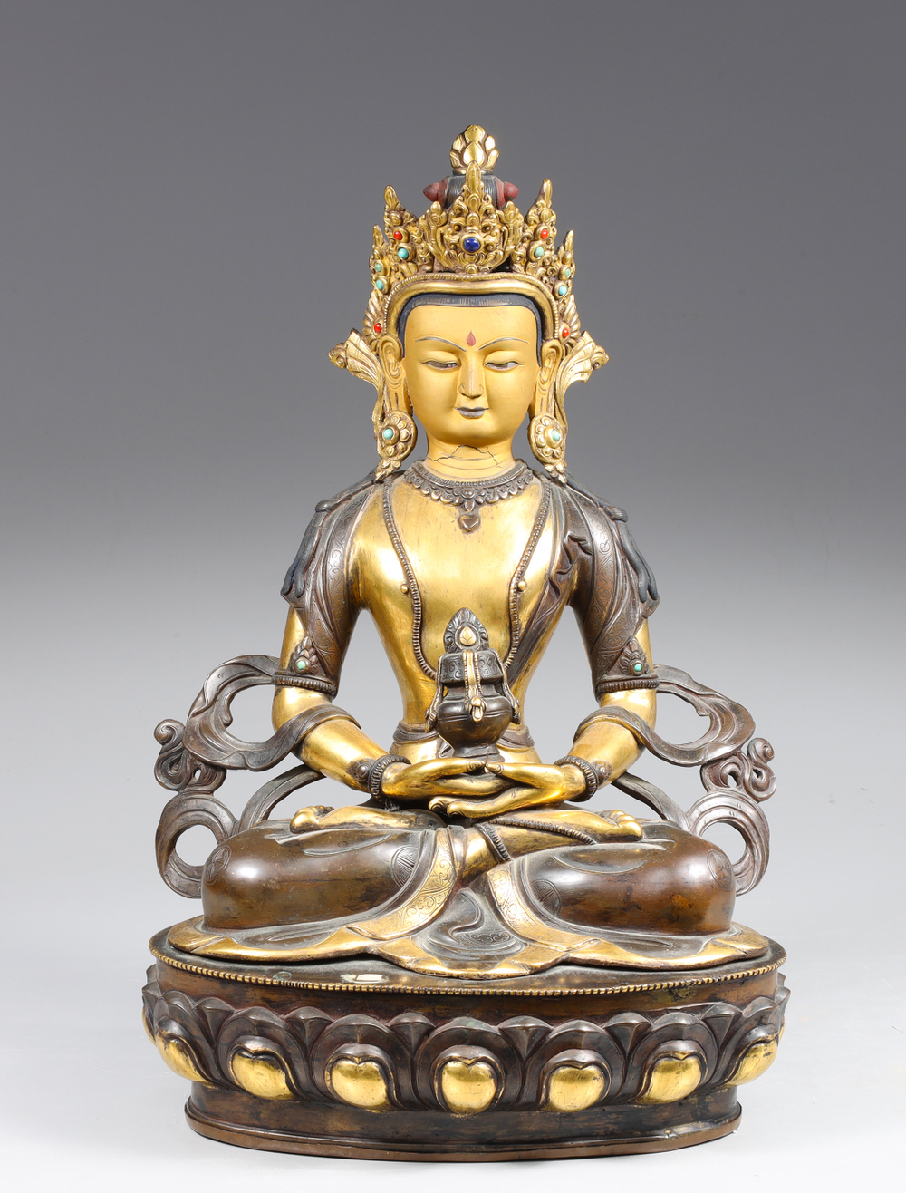 Auction photography of a Tibetan handcrafted gilt and patinated copper Amitayus Aparmita Buddha of Infinite Life statue in dhyana mudra with long-life vase, jeweled crown, and lotus throne. Museum and auction collection photography by Los Angeles commercial photographer Victor Koroma. Tibetan Gilt Copper Amitayus Buddha Statue —I.M. Chait Auction Photography