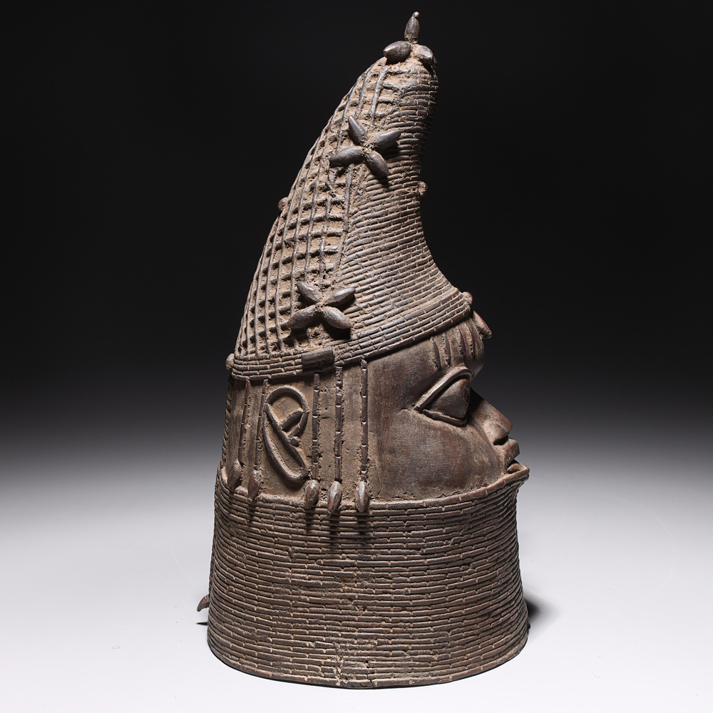 Auction photography of a Benin Bronze lost-wax cast commemorative head of the Iyoba Queen Mother of the Edo Kingdom Nigeria, with conical coral bead crown. Photographed for I.M. Chait Gallery and featured on LiveAuctioneers by Los Angeles commercial photographer Victor Koroma. Benin Bronze Edo Kingdom Queen Mother Iyoba — LiveAuctioneers I.M. Chait Victor Koroma