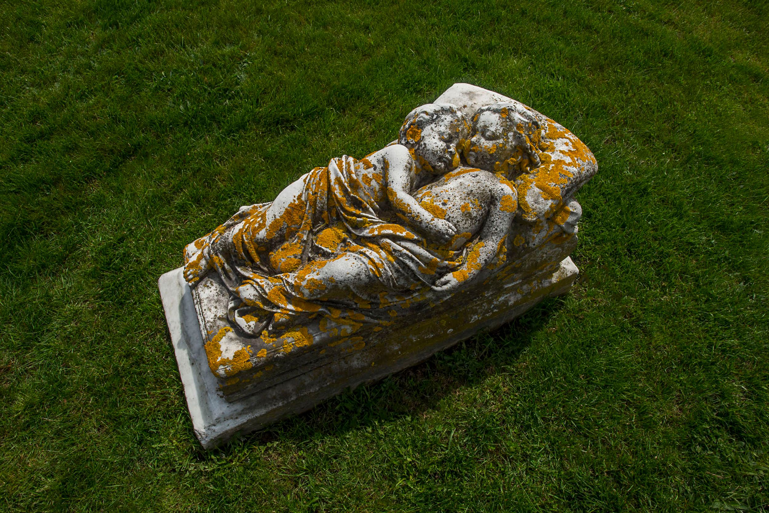Marble cemetery statue of 2 children lying together in Island Cemetery in Newport, RI. Children
