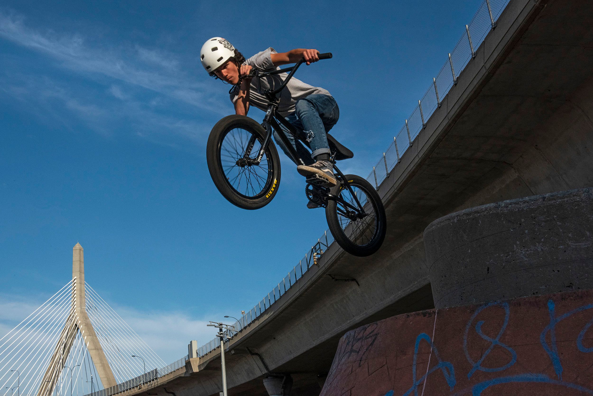 Color stop-action photograph of a BMX rider taking a jump at the Lynch Family Skateboard Park, Cambridge, MA Into the blue
