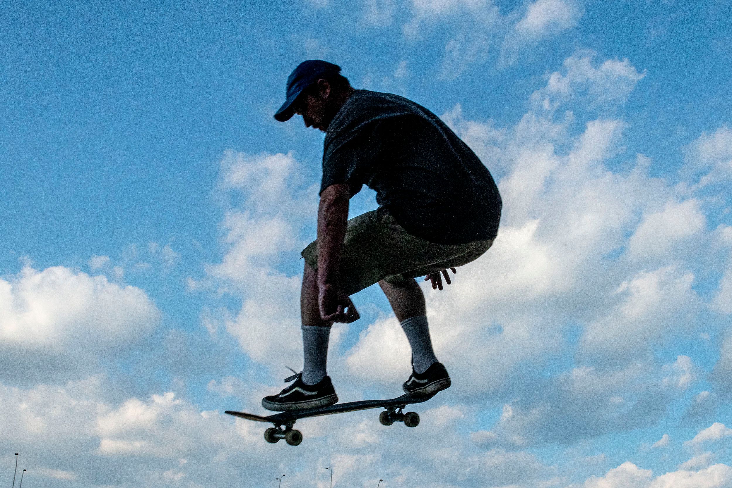 Stop action photograph of Ian Carroll, a skateboarder catching some air off a jump at the Lynch Family Skateboard Park, Cambridge, MA Air time