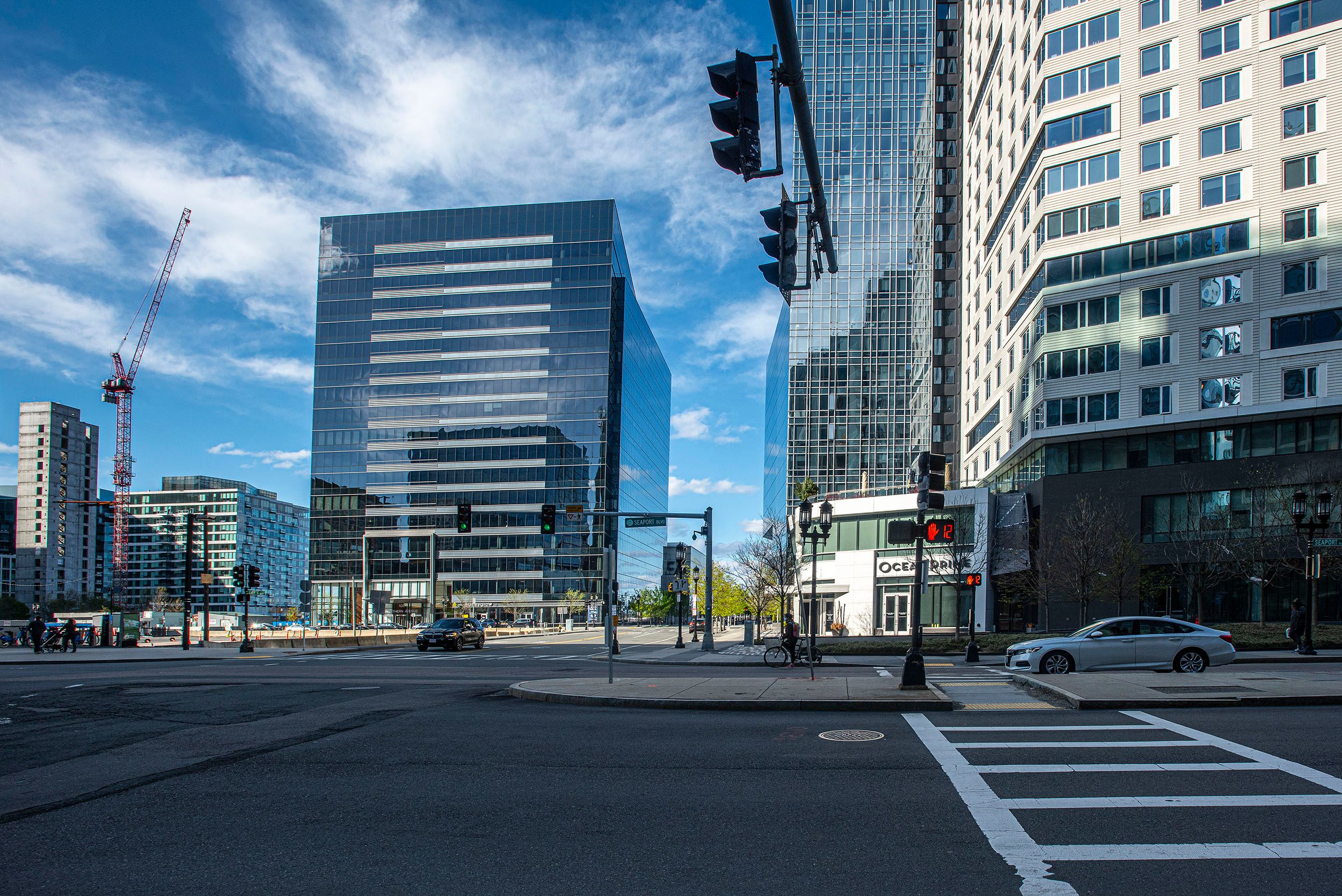 Photograph of the empty streets with a few cars and pedestrians walking around the Seaport District during the coronavirus pandemic. Boston, MA Empty Streets