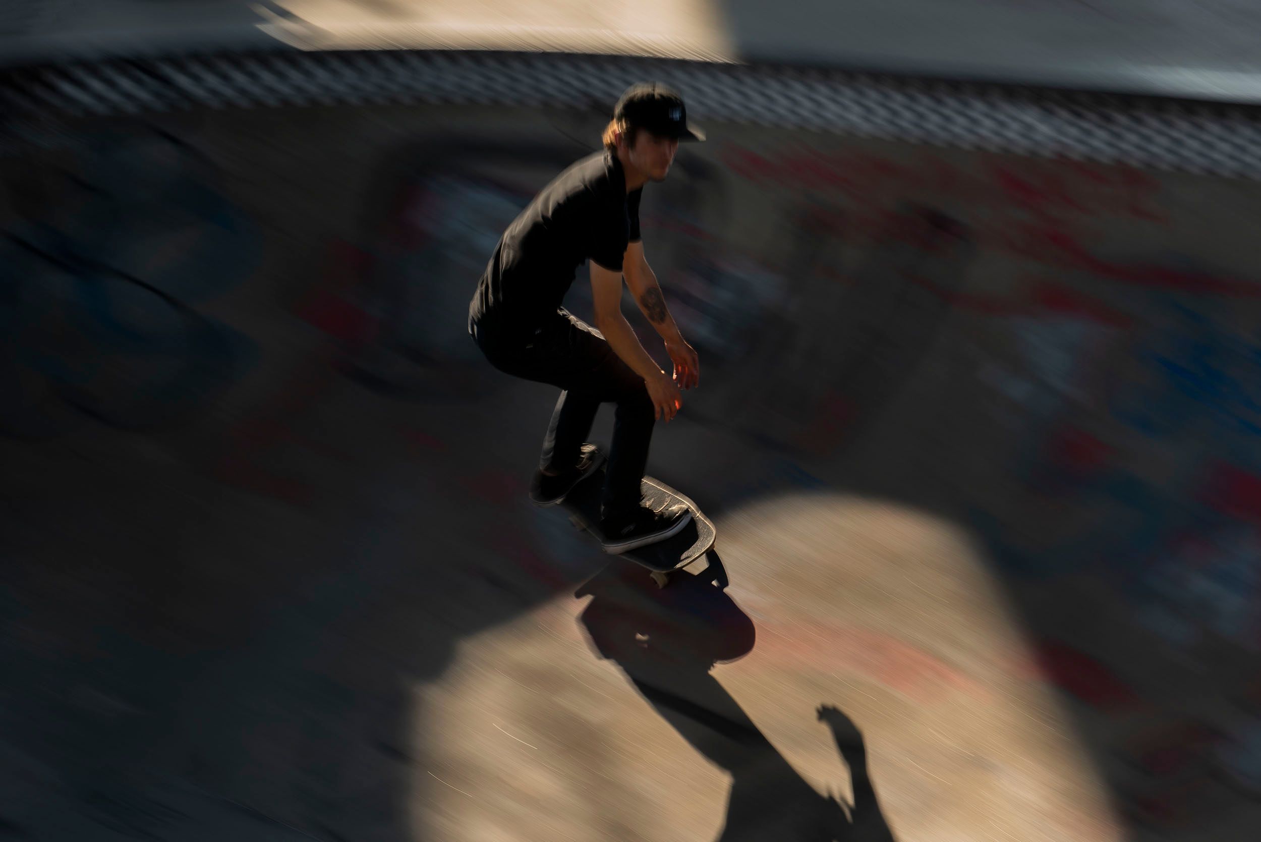 Color blur motion sports photograph of a skateboarder doing a spin thru the cement bowl at the Lynch Family Skateboard Park, Cambridge, MA Speed and Balance