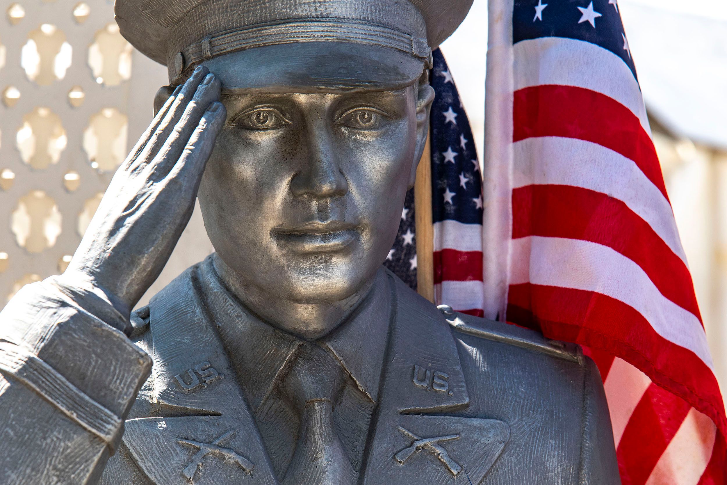 Statue of an American soldier soluting with an American flag.  Bizarroland