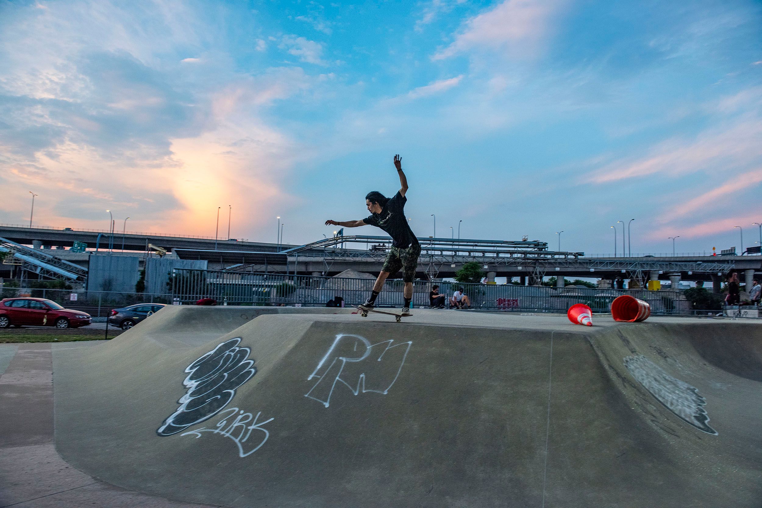 Color photograph of a skateboarder practicing his moves and tricks at dusk at the Lynch Family Skateboard Park, Cambridge, MA Balance
