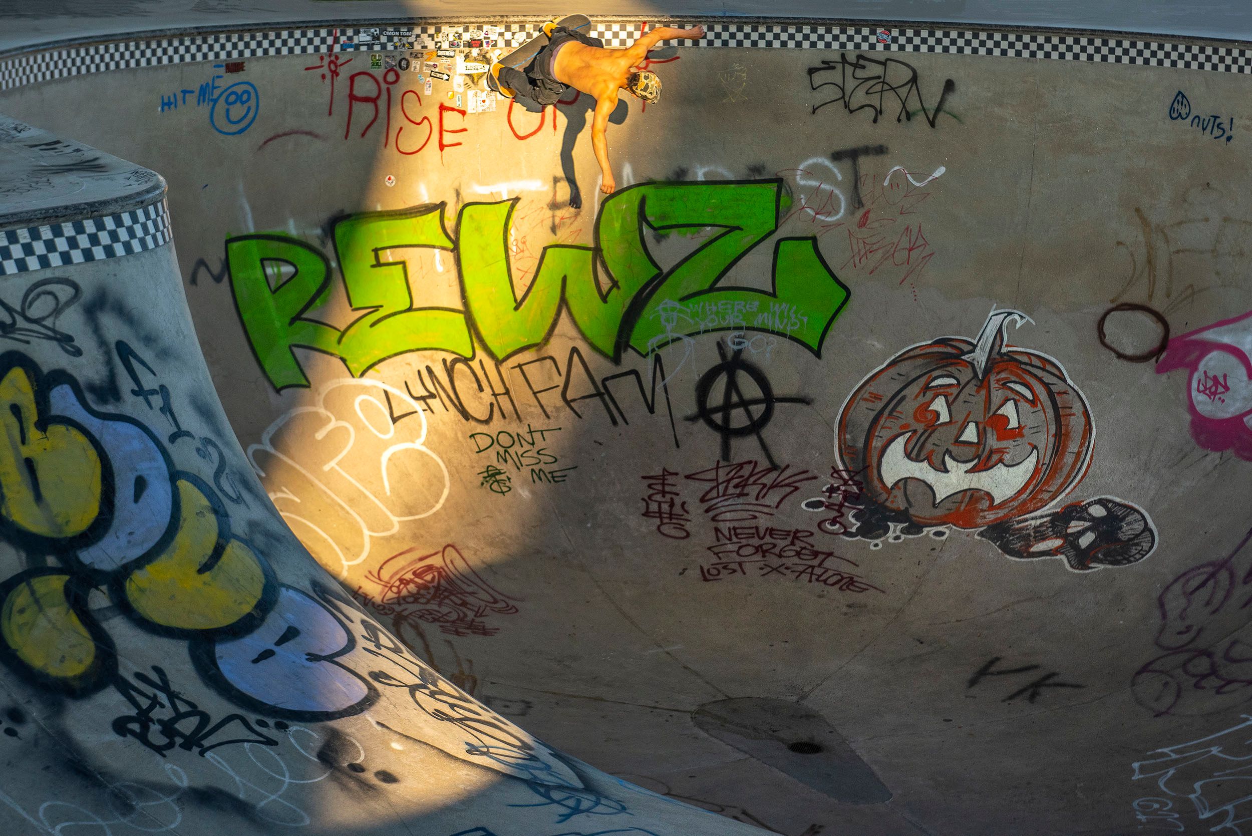 Color photograph of a skateboarder shredding the cement bowl at the Lynch Family Skateboard Park, Cambridge, MA Shredding the wall
