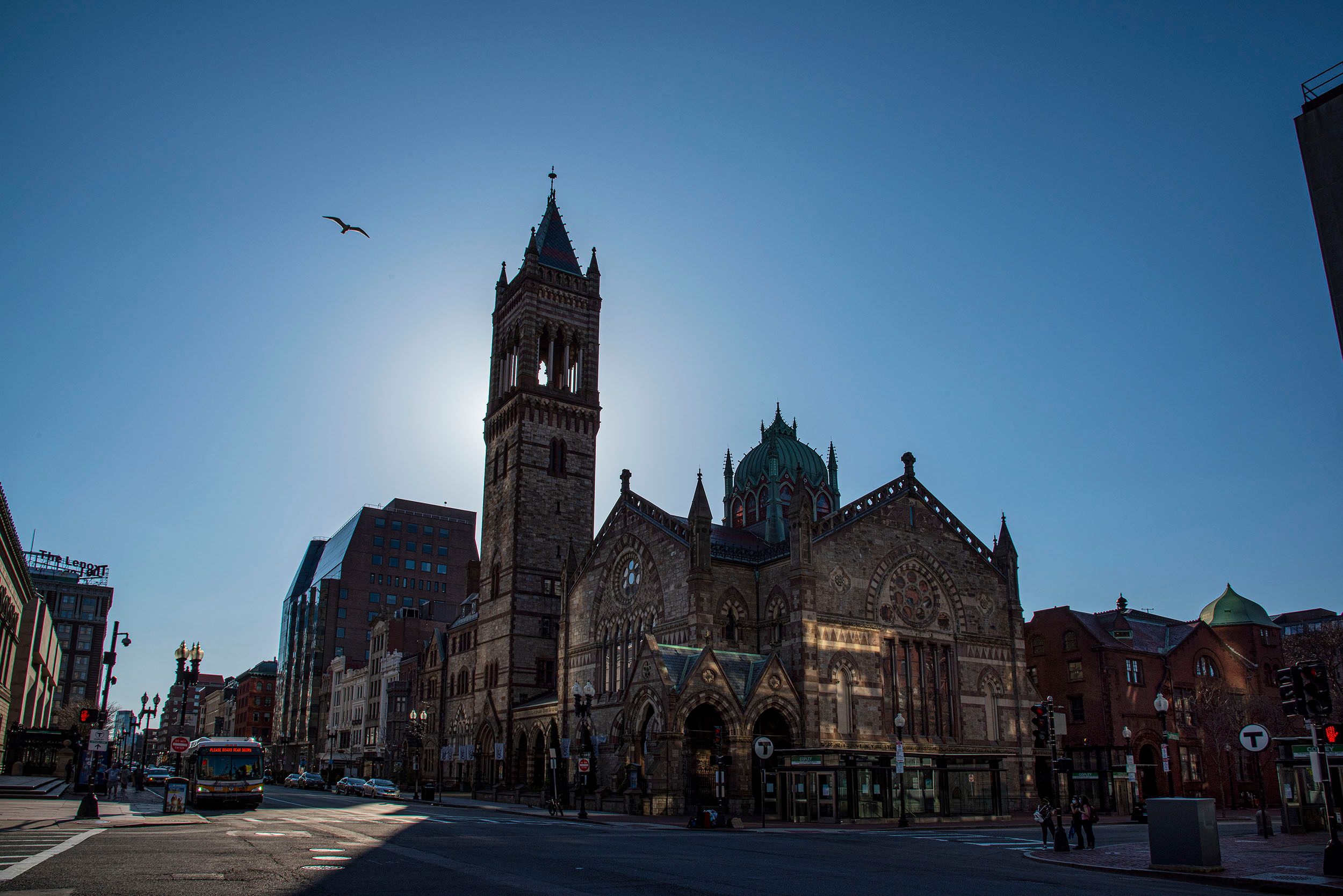 Horizontal color photograph of the empty streets in Copley Square with a lone bird watching over the city. Boston, MA  Closed until further notice