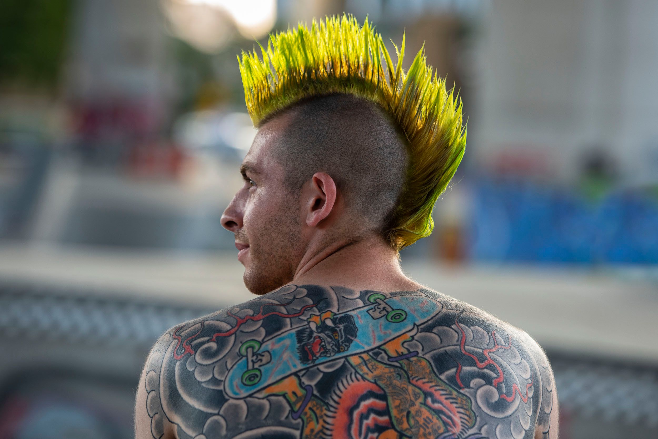 Color photograph of JC, a skateboarder with a mohawk and back tattoo's at the Lynch Family Skateboard Park, Cambridge, MA Styling