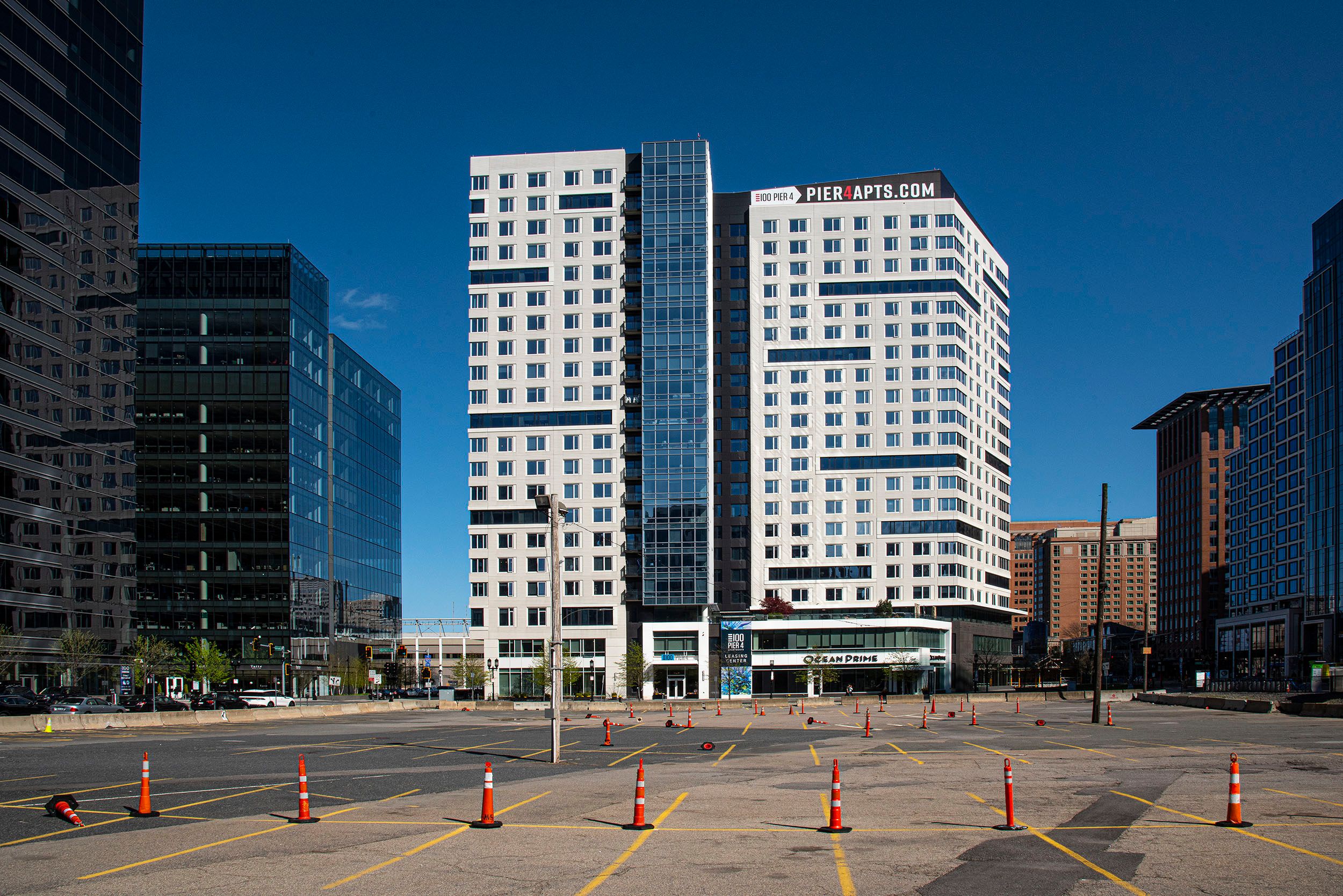Photograph of an empty parking lot with orange cones amongst the new construction. Seaport District. Boston, MA Empty Parking Lot