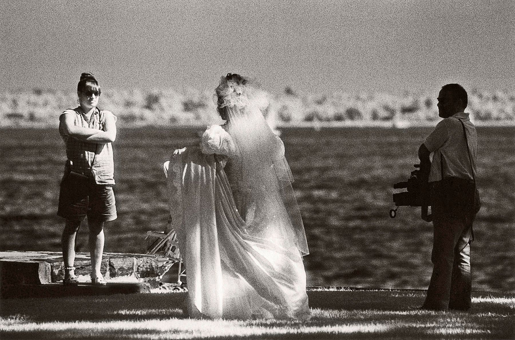 A new bride keeps her train closely in hand as she walks to her wedding photography session at Manor Park in Larchmont, New York. 1glowingbride