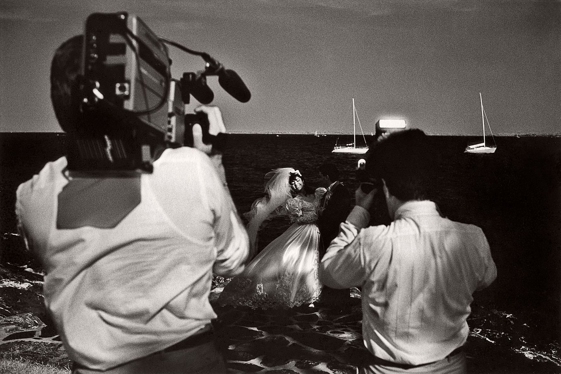 A new bride swoons as she becomes the focus of both a still photographer and a videographer at Manor Park in Larchmont, New York. 1videobride