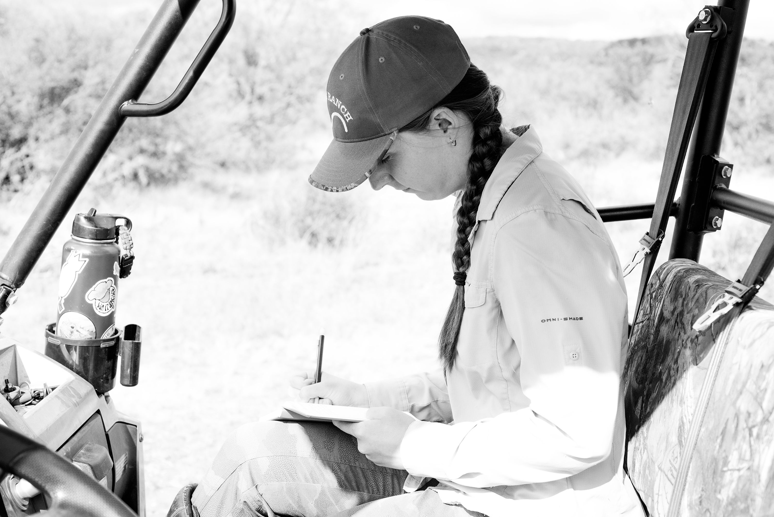 A Biologist writing notes in the field.