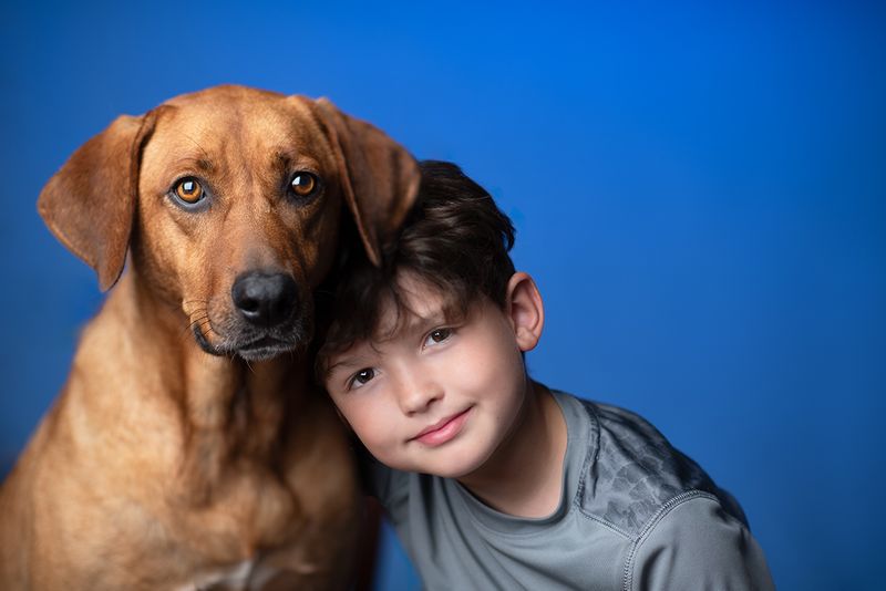 A boy and his dog studio portrait