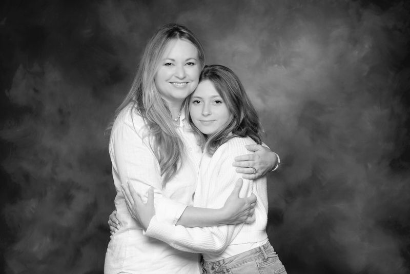 a black and white studio portrait of mother and daughter