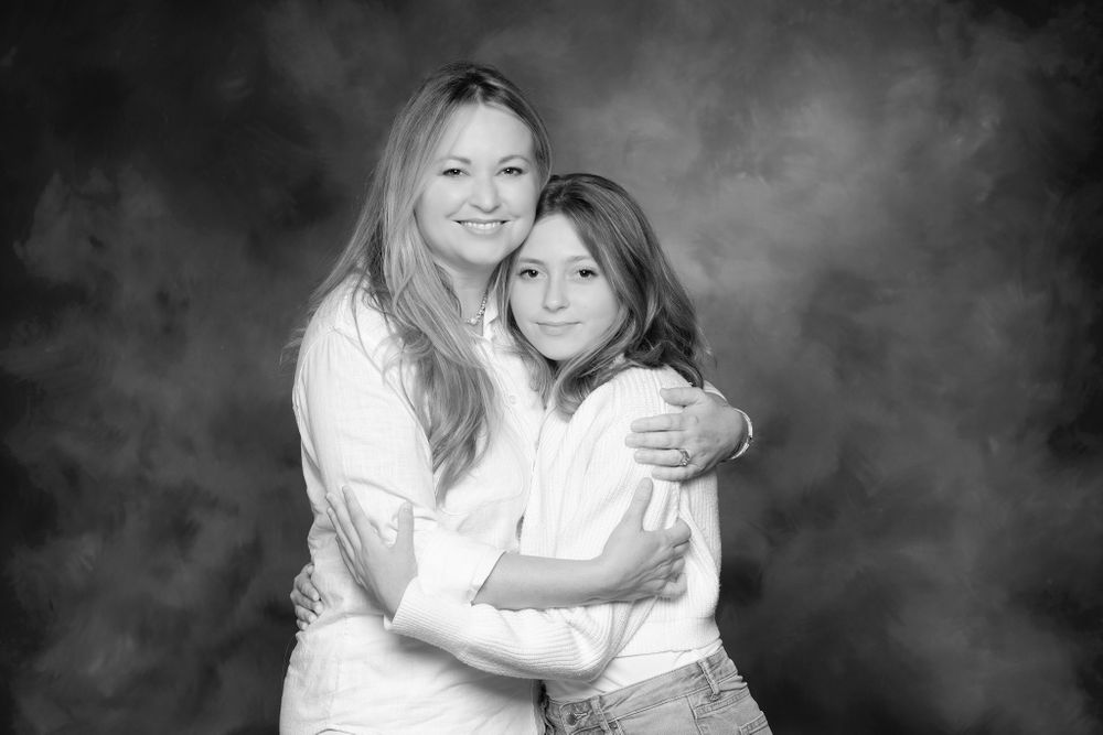 a black and white studio portrait of mother and daughter
