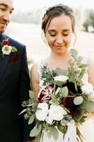 Bride and groom focus on bouquet 