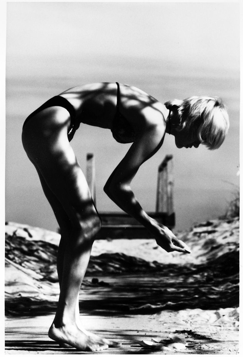 black and white photography of a woman looking at a beach shell black and white photography