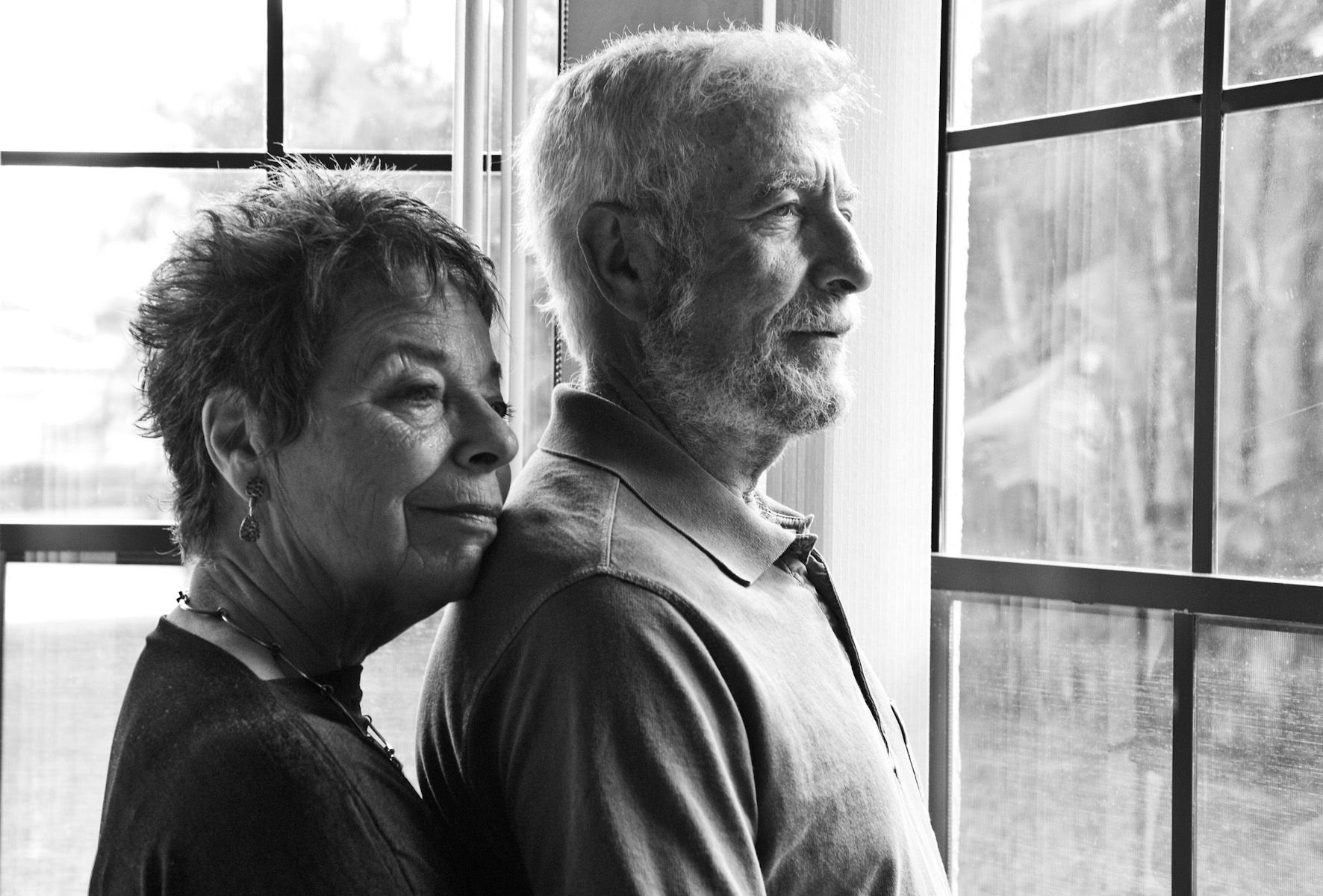 Senior married couple picture looking out the window married couple picture