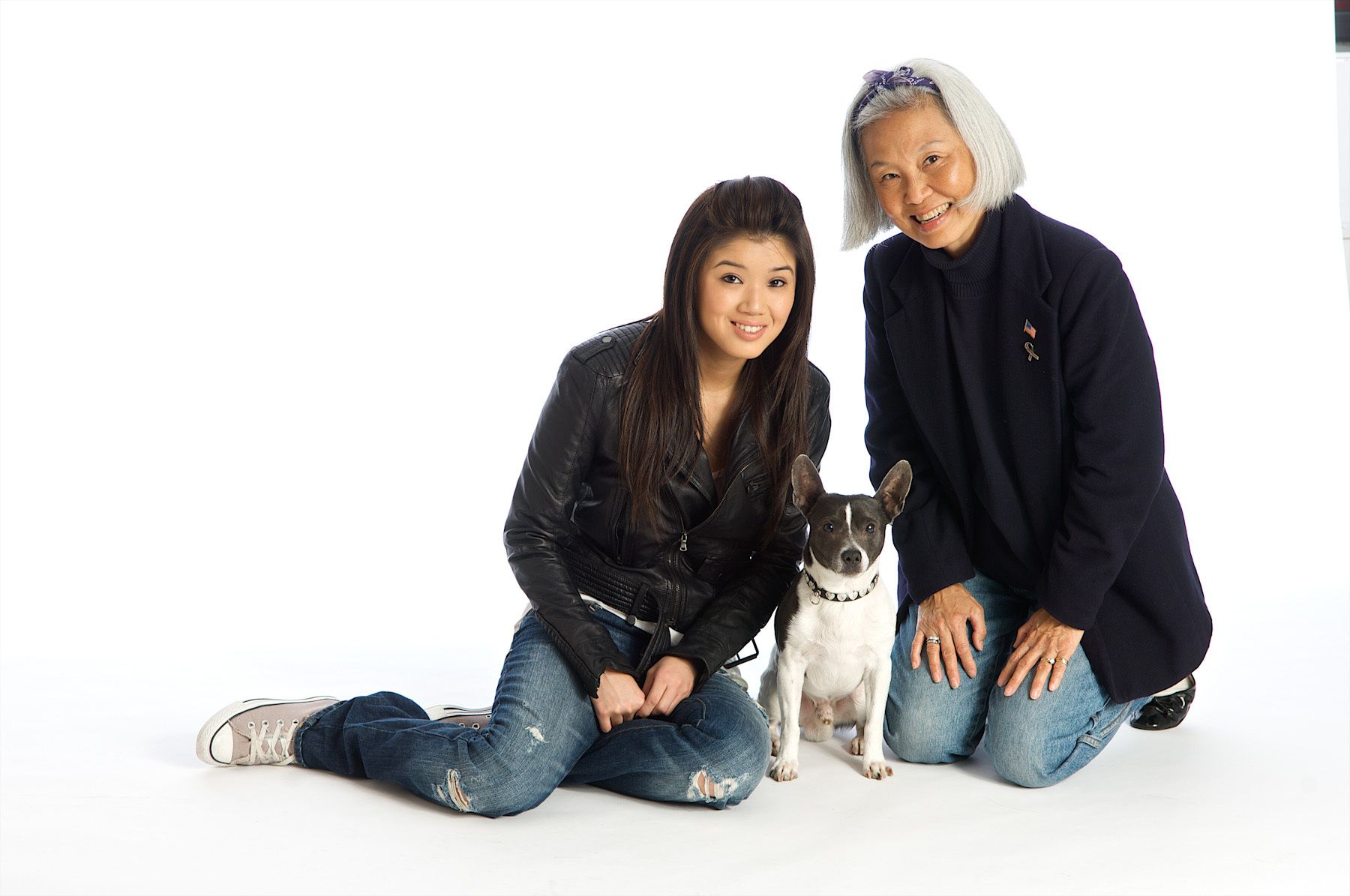 asian grandmother and grandaughter shot on white with dog Asian grandma and grandaughter,