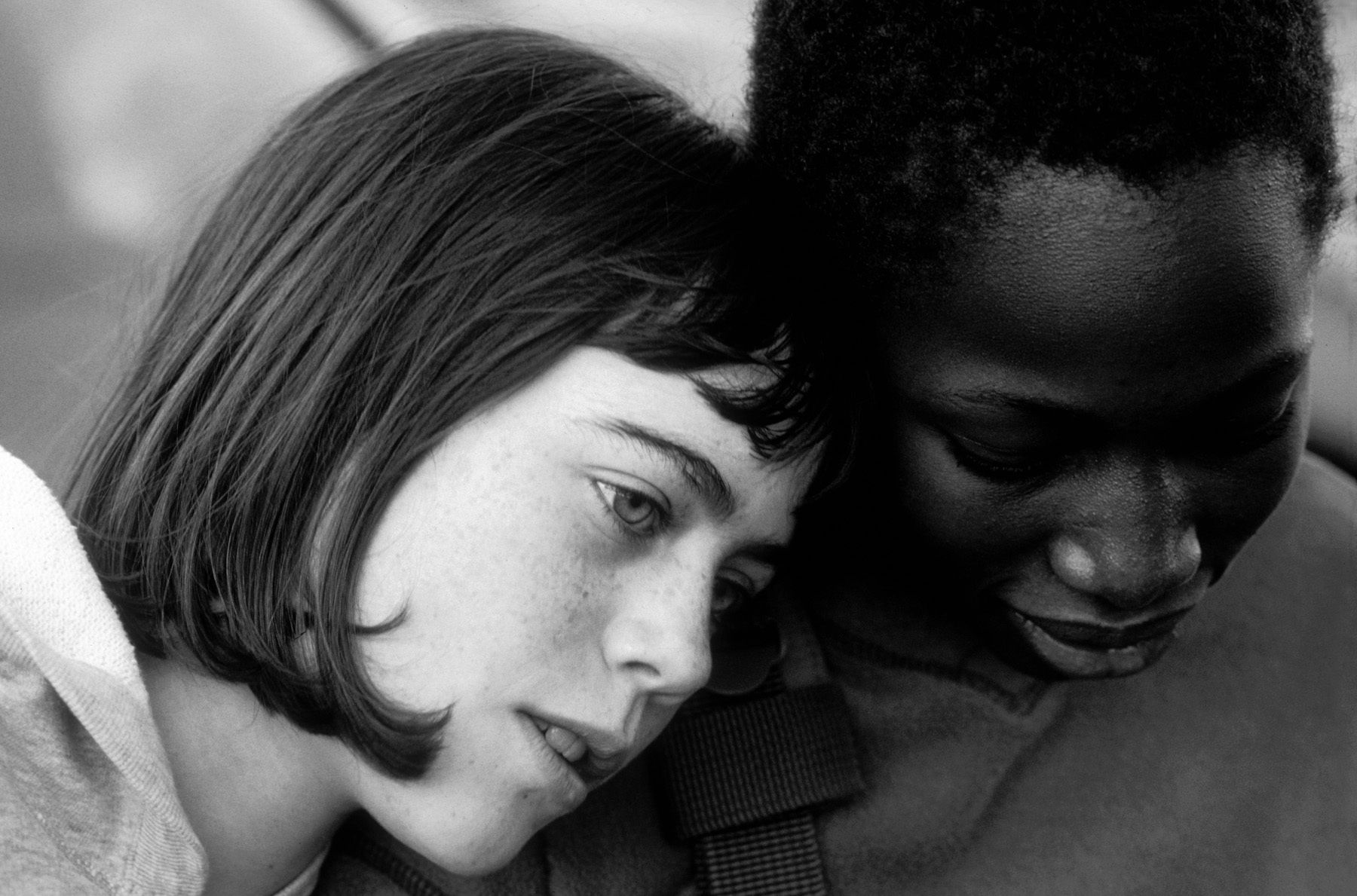 white 10 year old girl with her head on the shoulder of her black girlfriend white and black friends