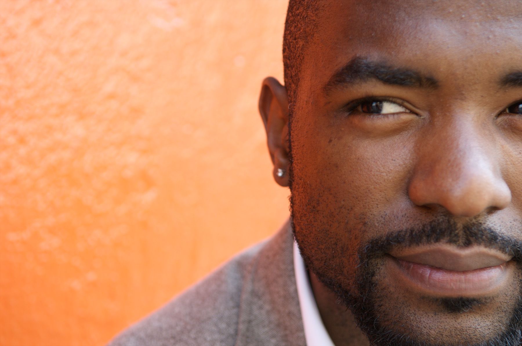 portrait of a black man's face with an orange background black man pictures