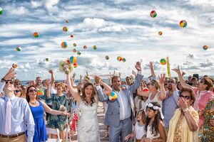 Wedding celebration throwing beach balls in the air