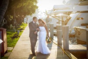Bride and Groom walking  on the dock in  Marina