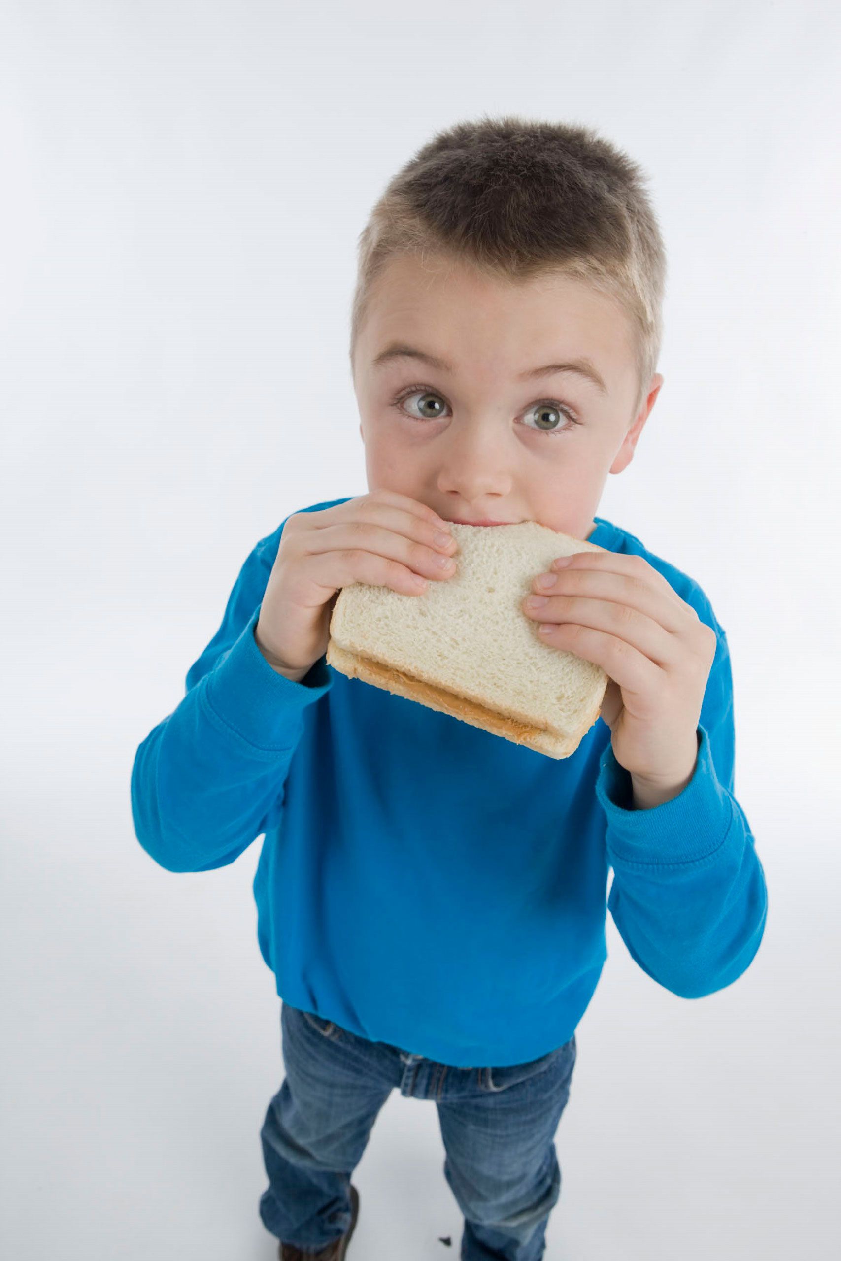 commercial studio advertising photoshoot  young boy eating sandwich 