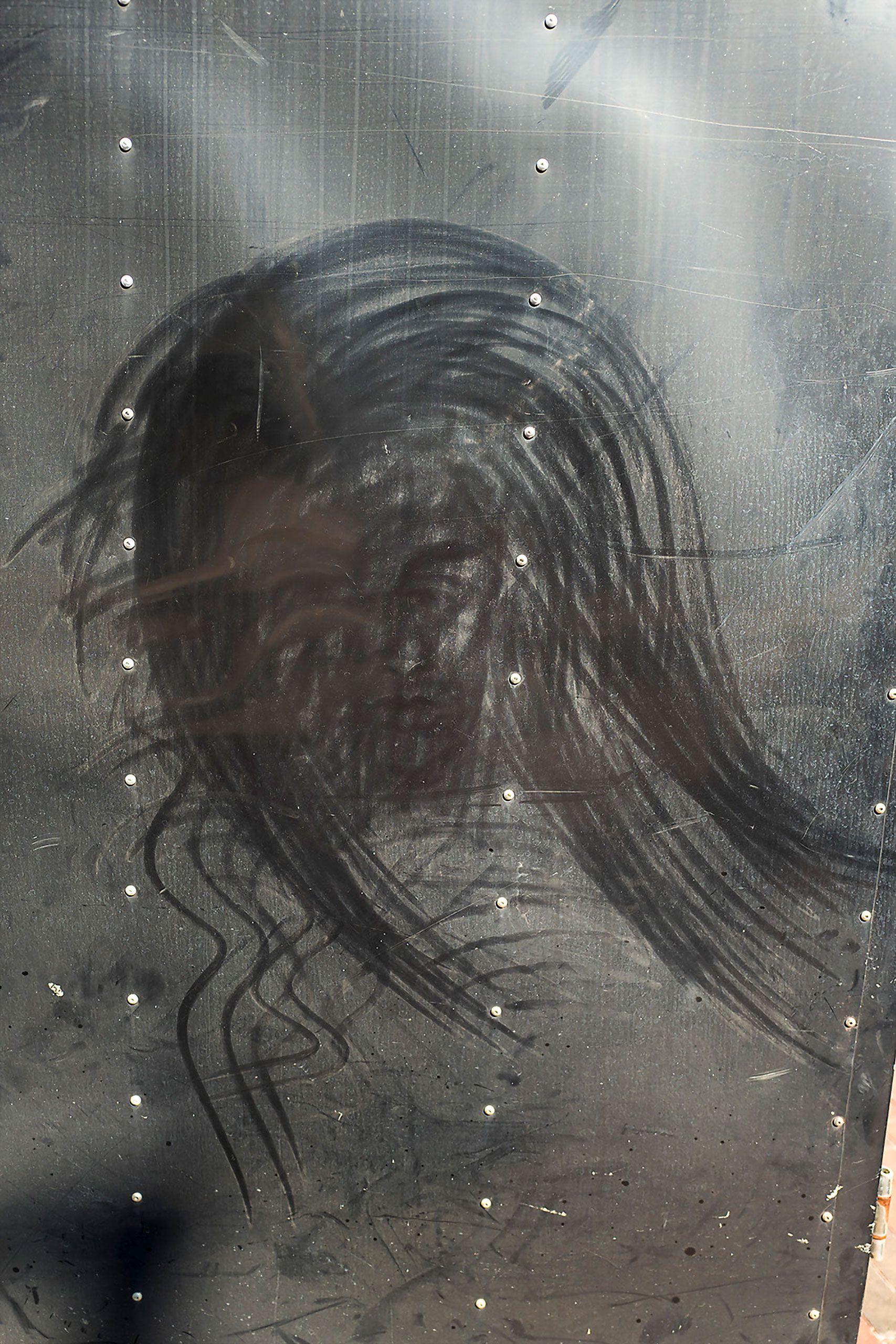 Face or hair  on metal wall