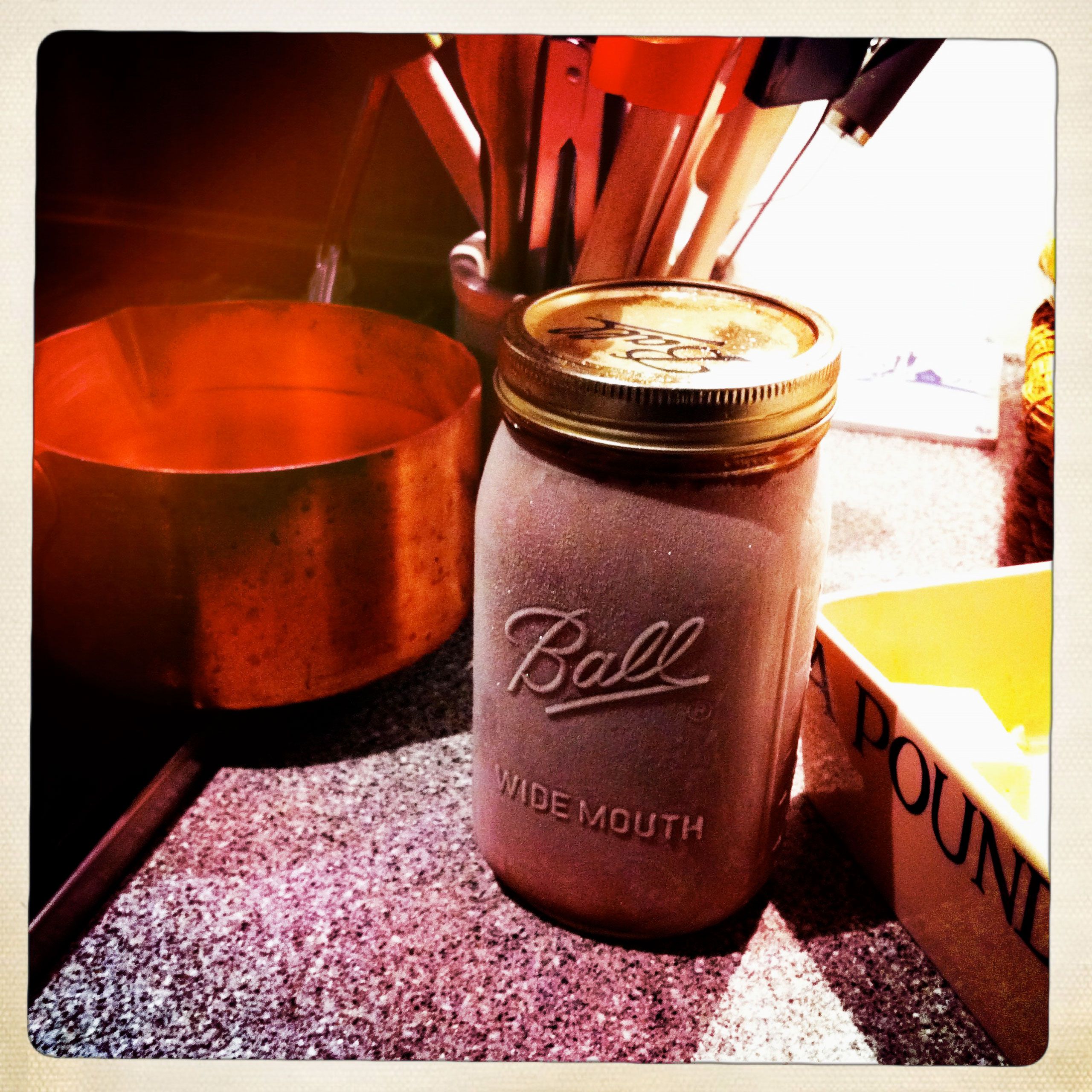 Frozen ball jar full of hot fudge in kitchen on counter