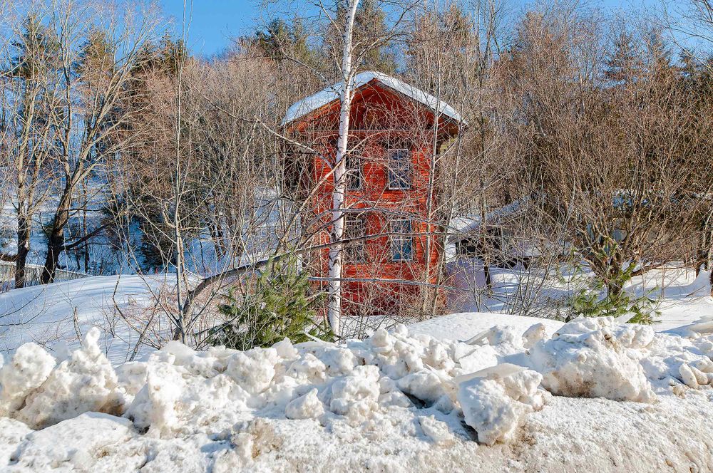 Tiny unusuall old house in Forks Maine in winter time snow and ice