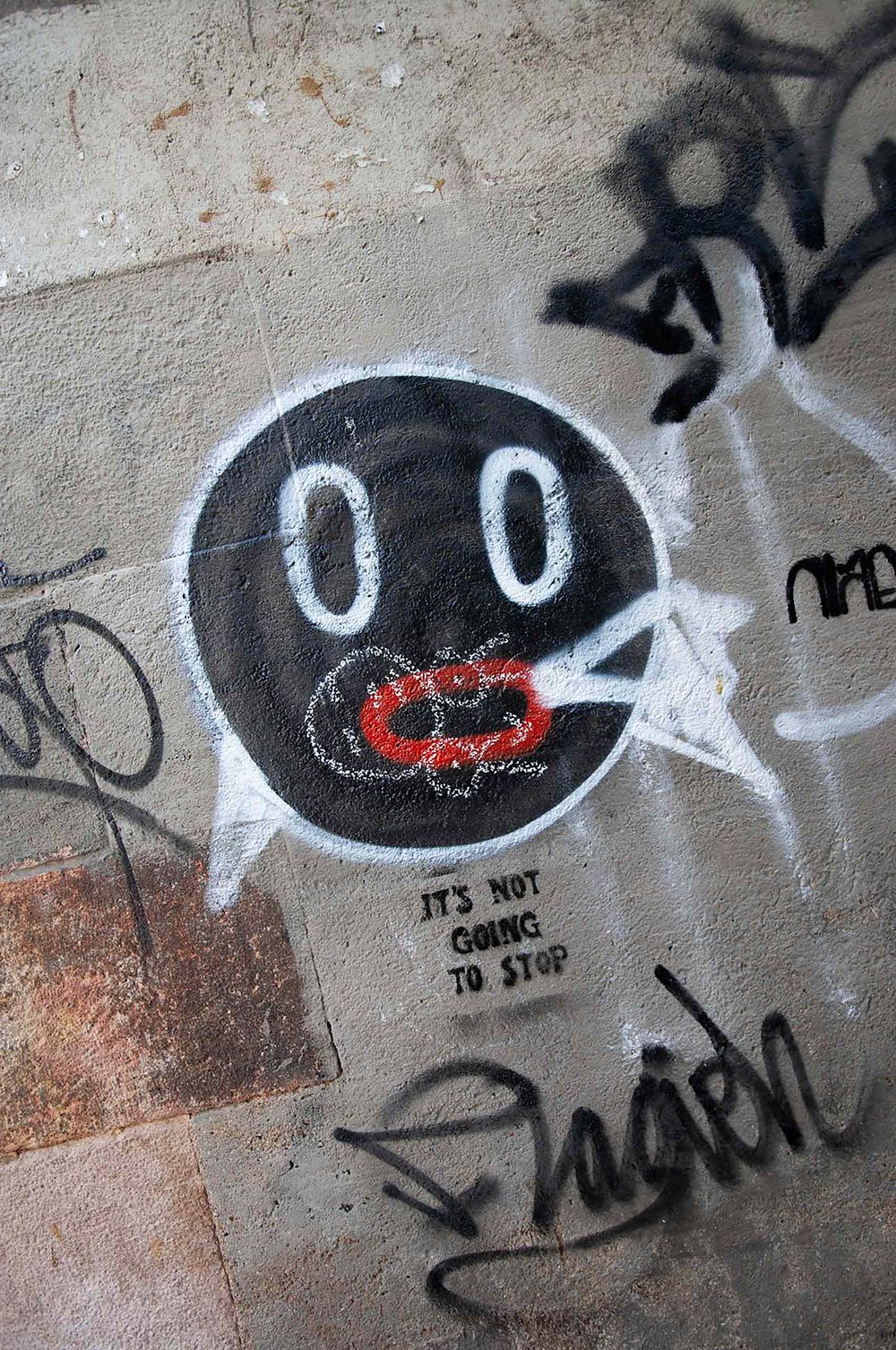 Graffiti stencil of it's not going to stop  in Barcelona Spain . Smoking face too