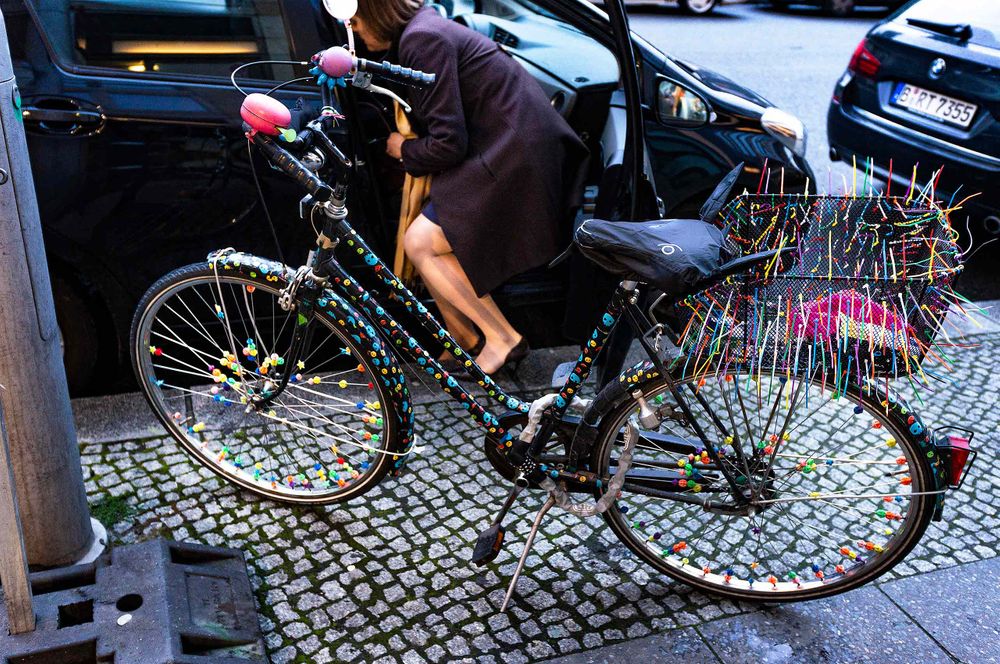 Decorated bycycke in Berlin and some fine legs on a woman getting into a minivan