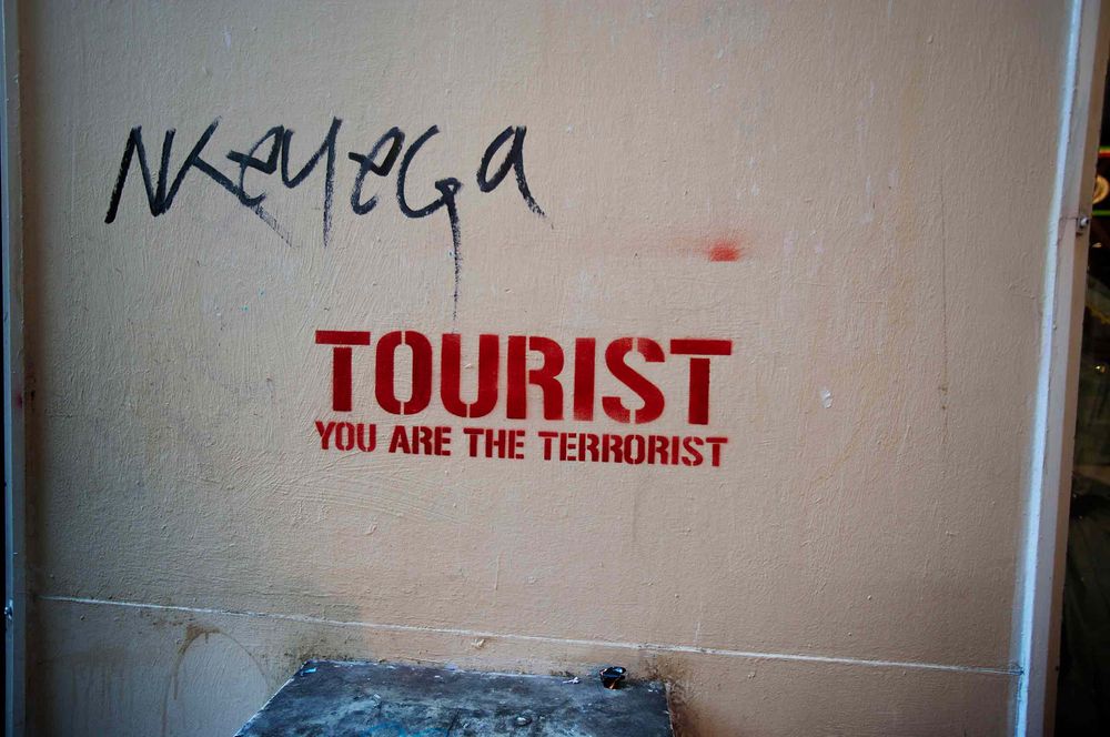 Graffiti stencil of Tourist you are the terrorist in Barcelona Spain
