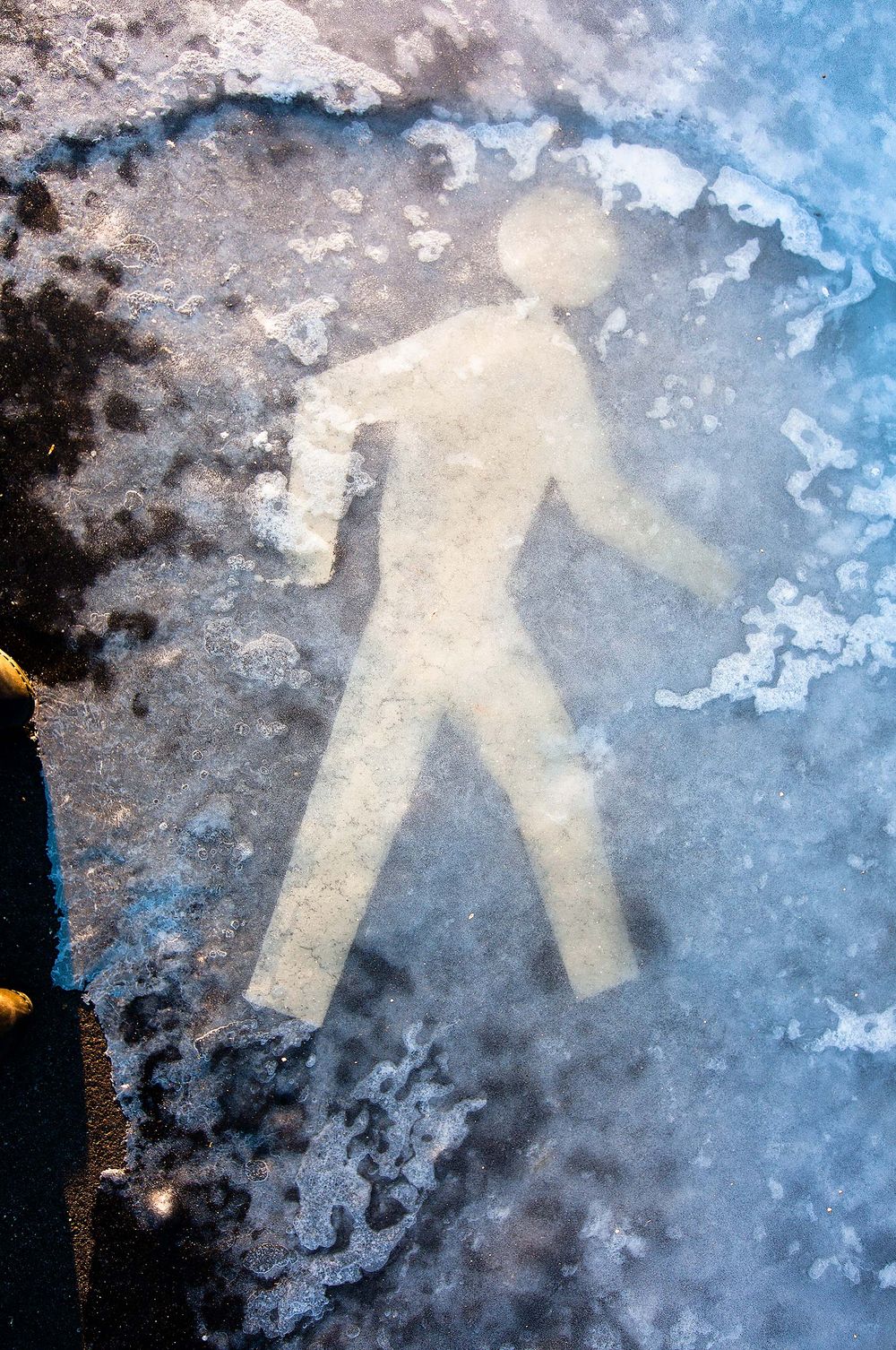 Pedestrian crossing icon man frozen in ice in winter in Manchester new Hampshire