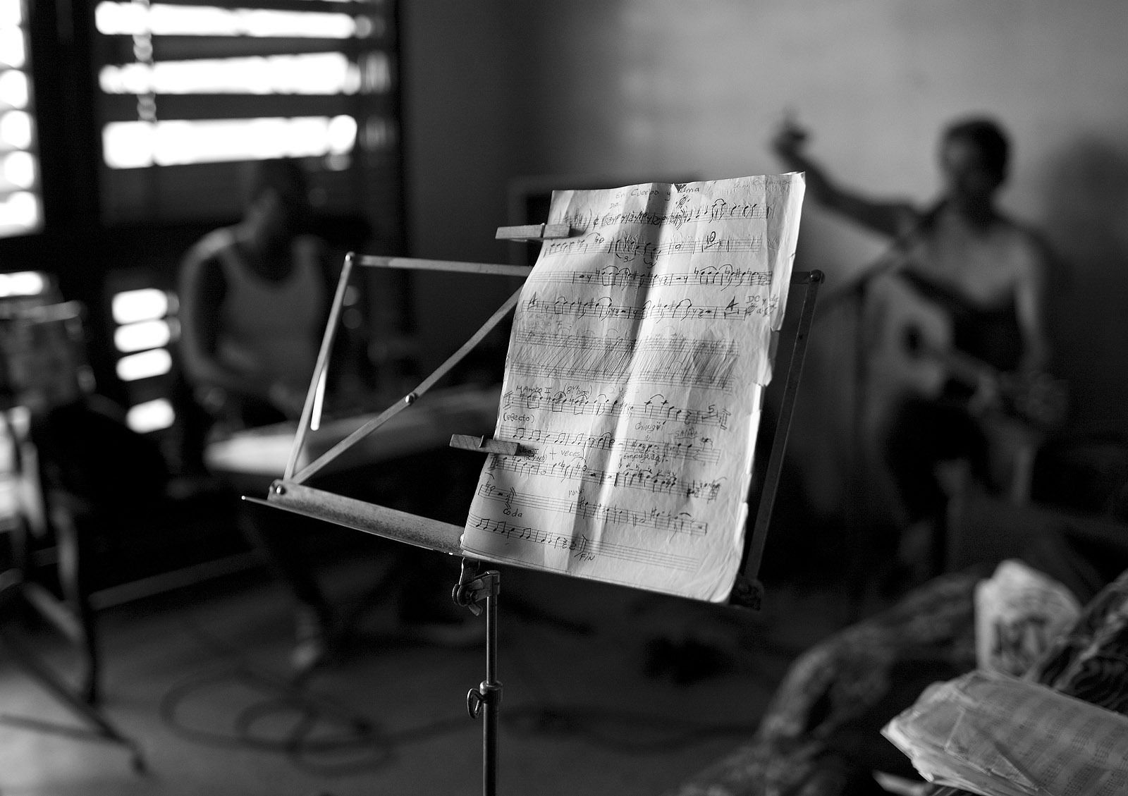 a handwritten music chart sits in the middle of an afternoon rehearsal of the band guacachason, near the promenade in havana's centro historico. chart