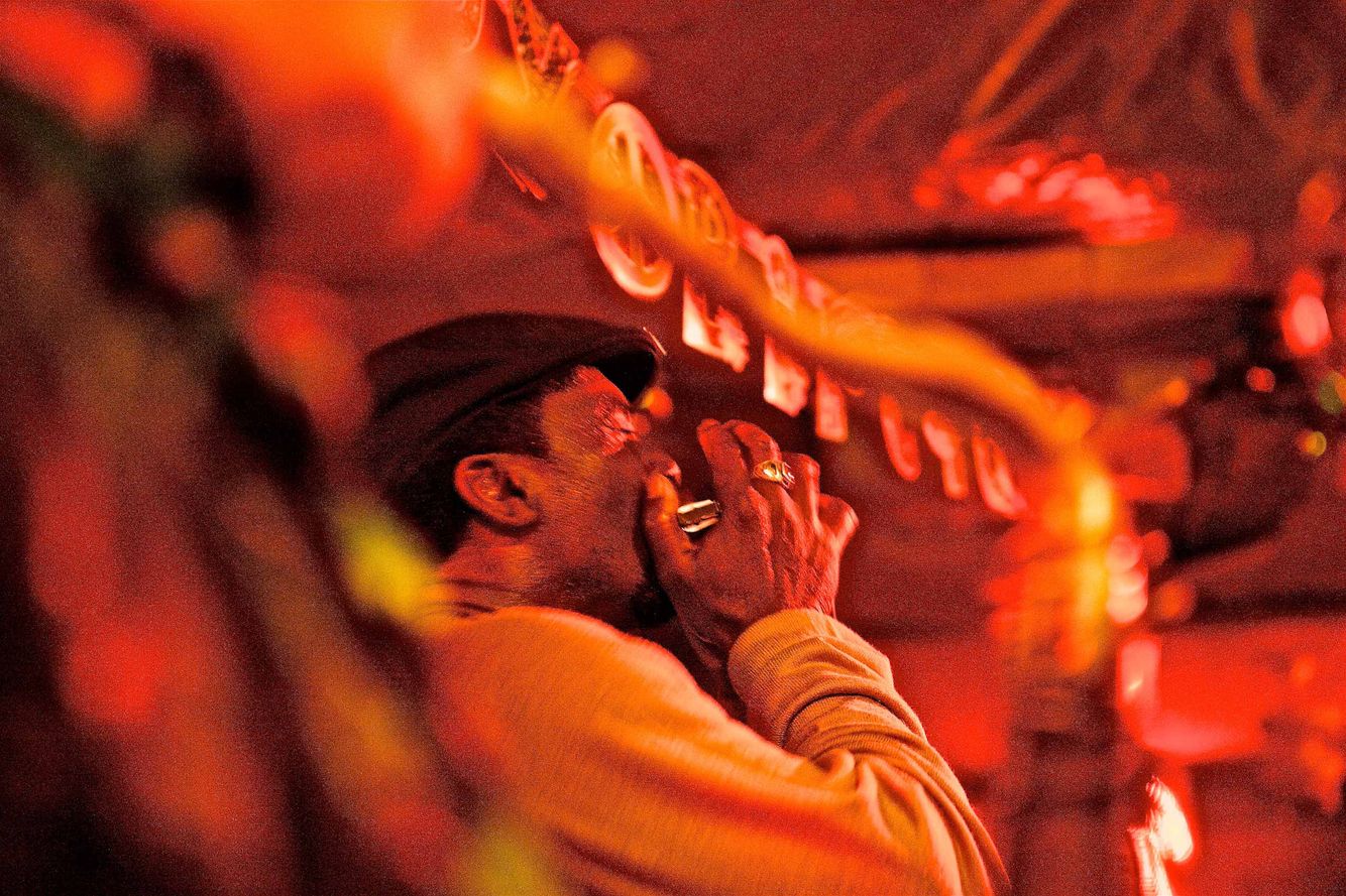 An action photo of Terry Harmonica Bean playing harp & performing at Red's Lounge Juke Joint in Clarksdale, Mississippi. Photos of various juke joints with people & locations on and around Highway 61, i the delta, and along the Blues Highway. These photographs were made for a number of projects such as the documentary We Juke Up In Here, the web series Moonshine & Mojo Hands and a passion project to document the beautiful Mississippi delta lifestyle. As an on location photographer, lifestyle photographer & location commercial photographer, this was one the best long term projects ever that captures southern Americana! Terry Harmonica Bean Playing Harp at Red's Lounge Juke Joint