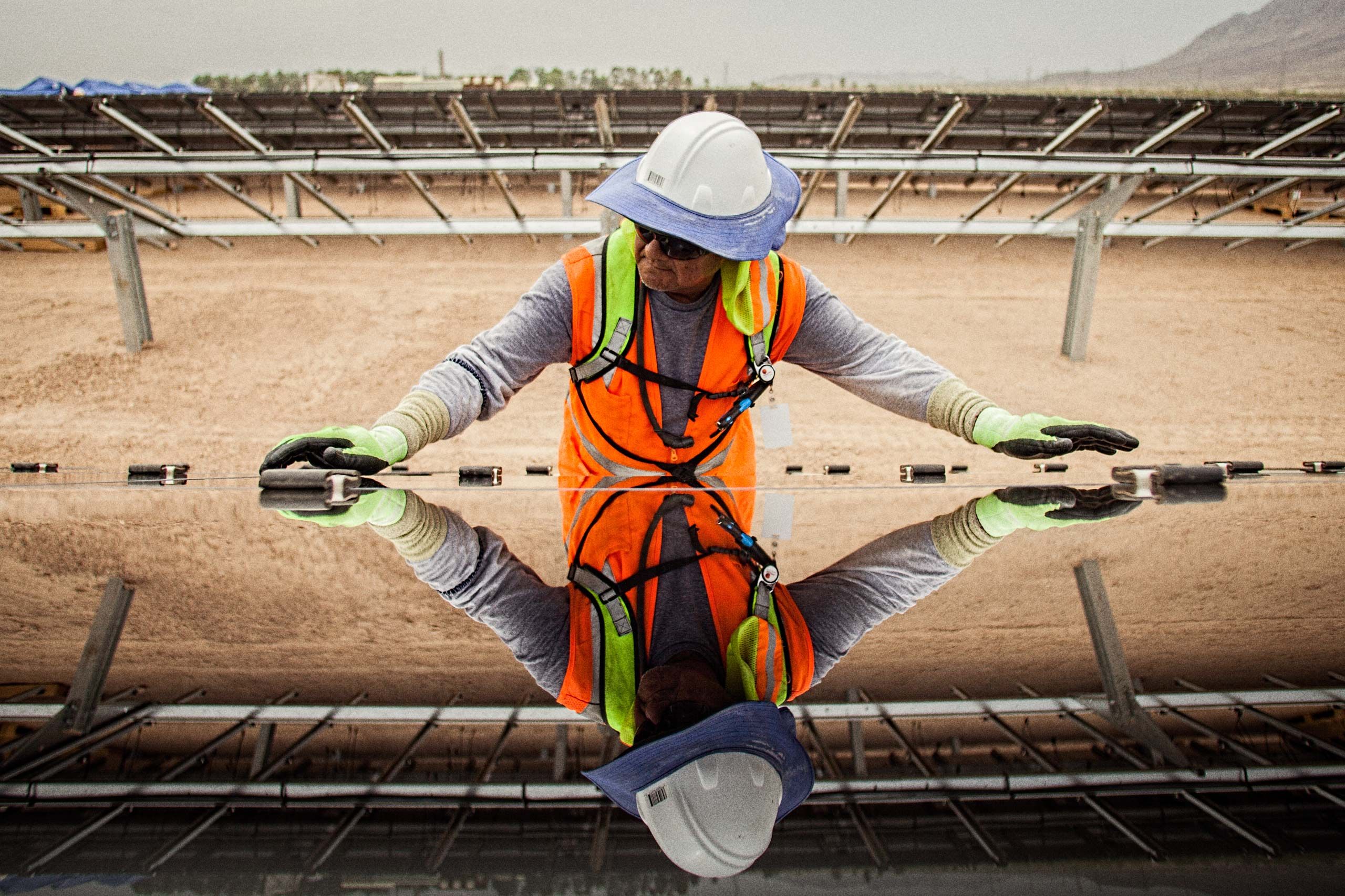 Worker Installing a Solar Panel Showing His Reflection