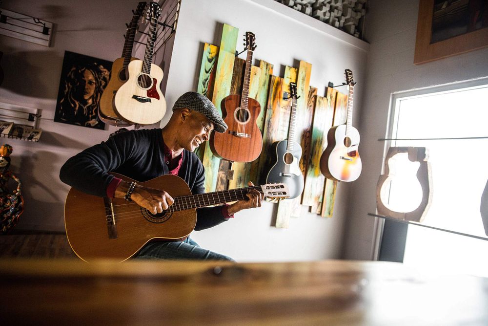 Man having a good ole time jamming on a guitar in a guitar shop, advertising photographer, on location photographer, commercial photographer St. Louis Man Playing guitar