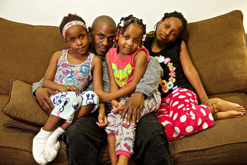 A environmental portrait of a family at home, Three Daughters and their Uncle, who is their caretaker. Photographed for a United Way advertising campaign. I am a advertising photographer, on location photographer & location commercial photographer. Photo of one of the many people that the United Way is assisting. Family Photo At Home