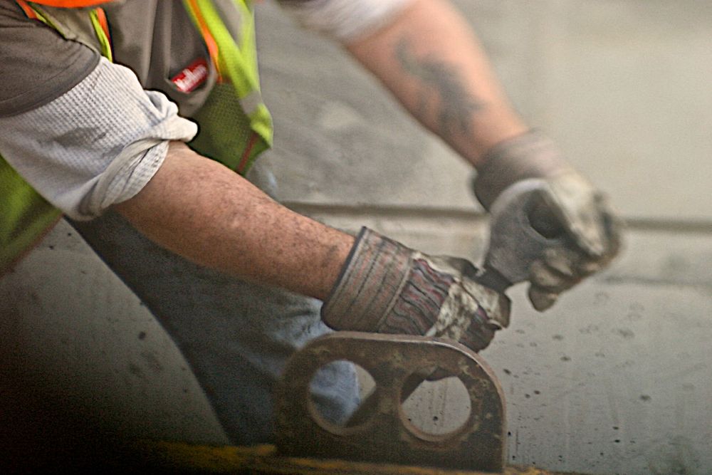 A photo of a close up of a mans gloved hands pulling on a wrench, selective focus and shallow depth of field. Closeup of man With Wrench