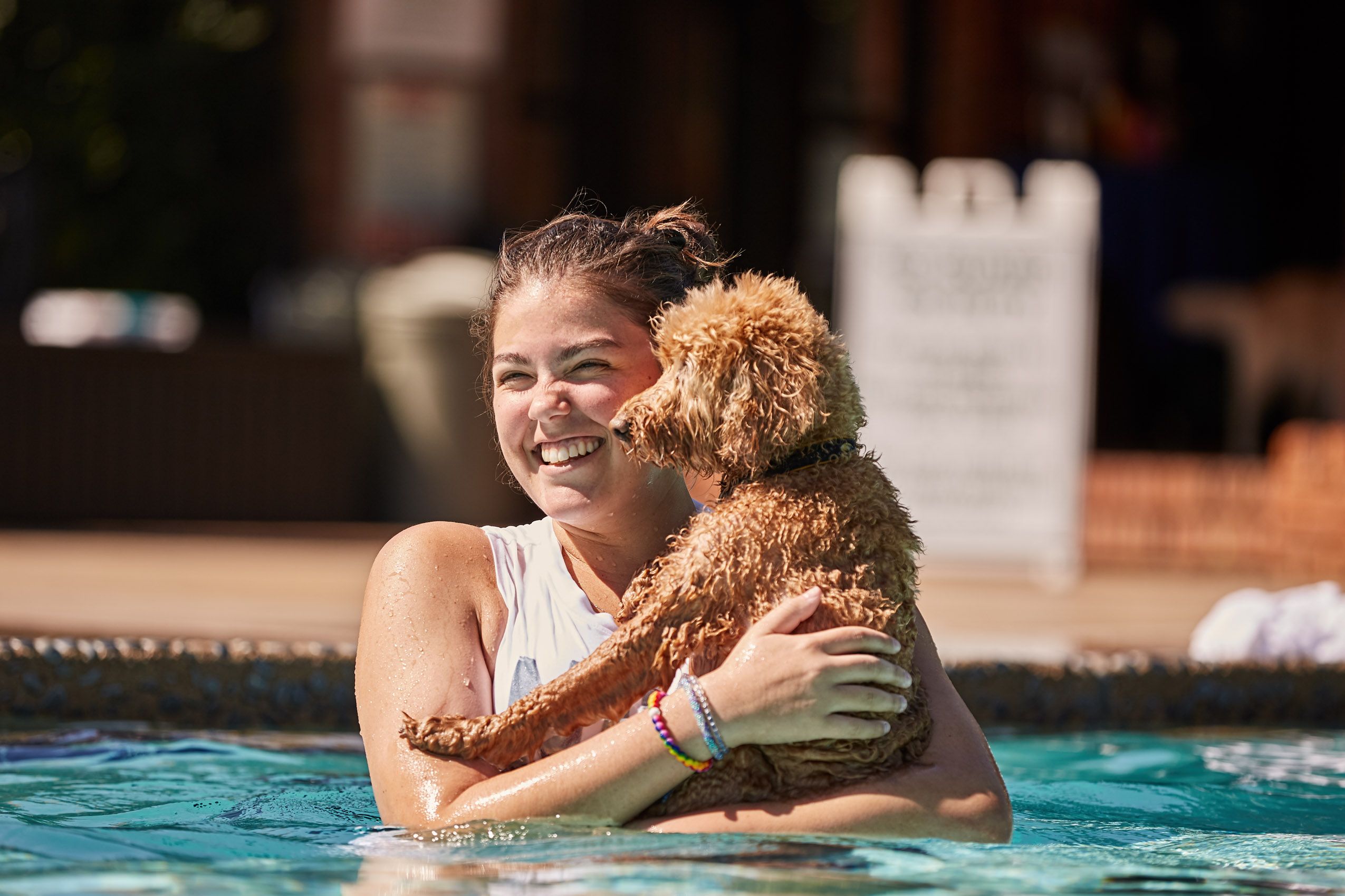 Girl Holding Dog in Pool