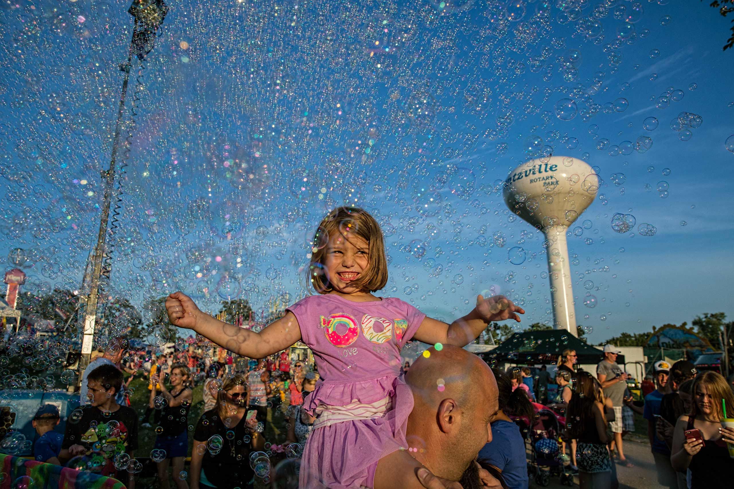 Girl On Shoulders Surrounded By Bubbles