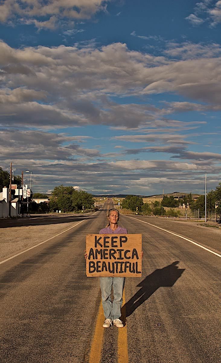 Woman Holding Keep America Beautiful Sign in the Middle of the Road